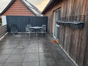 un patio avec une table et des chaises sur un bâtiment dans l'établissement Ferienwohnung 2, à Northeim