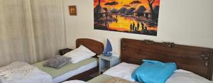 フラにあるVaste maison Fouras 15 pers 6 chbres meublé 3*のベッドが2つあり、壁に絵が飾られた寝室