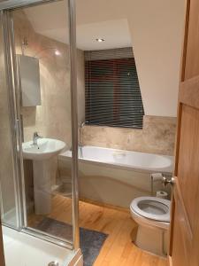 a bathroom with a tub and a toilet and a sink at Salvi's Hideout in Sarisbury Green