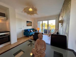 a living room with a statue on a glass table at T3 Lumineux avec super Terrasse in Saint-Gilles-Croix-de-Vie