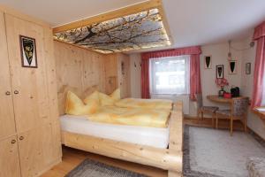 a bedroom with a bed and a table and a window at Haus am Rain in Partenen