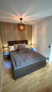a bedroom with a large bed with a chandelier at Moderne Ferienwohnung beim Augustinerkloster direkt in der Altstadt in Erfurt +9 photos