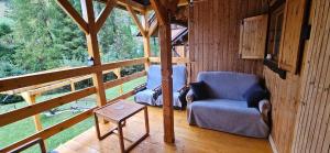 a room with two chairs and a dog in a cabin at Mój Domek z kominkiem i jacuzzi na wyłączność in Wisła