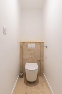 a bathroom with a white toilet in a stall at Zest Boheme Villeurbanne in Saint-Priest