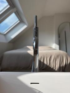 a bedroom with a bed and a sink with a window at Dakappartement V, 2de verdiep TML in Willebroek