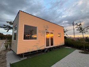 杜尔卡尔Tiny House Base Camp Granada Camping的坐落在一片草地上的一座小房子