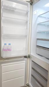 an open refrigerator with two bottles of milk in it at 헤세드 in Sŭngch'ŏn-ni