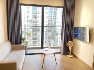Phú ThúにあるThe Sakura - SA2 Vinhomes Smart Cityのソファと大きな窓のあるリビングルーム