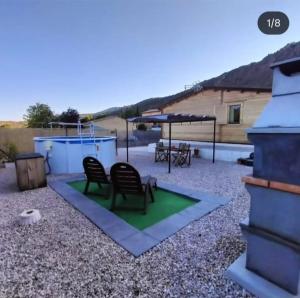 a patio with two chairs and a table and a ping at Las Casas de Durón in Durón