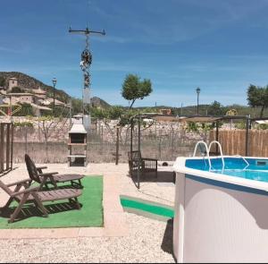 a backyard with a pool and a picnic table and a swing at Las Casas de Durón in Durón
