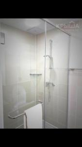 a bathroom with a glass shower with a towel at Korkem in Zhezdi