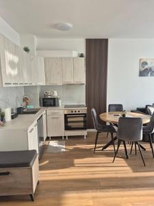 a kitchen and dining room with a table and chairs at Apartment VIP in Subotica