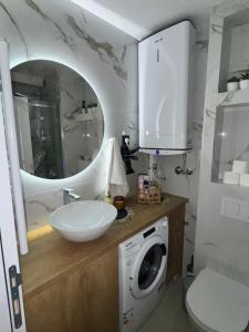 a bathroom with a sink and a washing machine at Fairy tale apartment 9 in Voždovac +14 photos