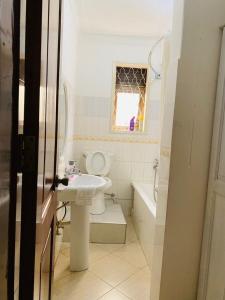 um banheiro com uma pia, um vaso sanitário e uma janela em Hidden beautiful Modern Apartment em Entebbe mais 76 fotografias