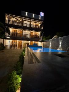 a building with a swimming pool at night at Villa Rosella in Ahangama