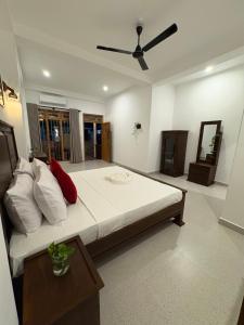 a bedroom with a large bed with a ceiling fan at Villa Rosella in Ahangama