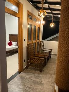 a room with two wooden chairs and a bed at Villa Rosella in Ahangama