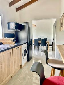 a kitchen with a refrigerator and a table with chairs at Nid Créole in Vieux-Habitants +19 photos