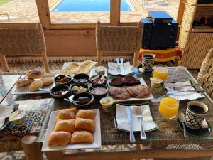 Una mesa llena de alimentos para el desayuno y jugo de naranja. en Tigmi Timhar, en Nkob