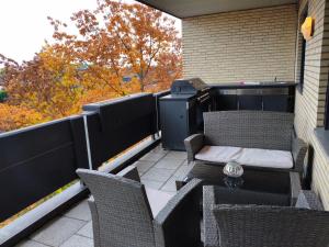 a balcony with chairs and a table and a grill at PanoramaLoft Warendorf in Warendorf