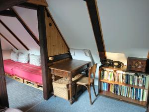 a room with a desk and a bed and a book shelf at Chalupa Adélka in Hejnice