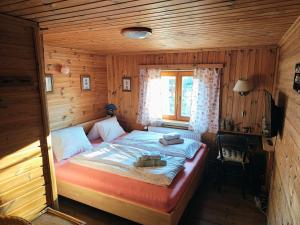 a bedroom with a bed in a wooden room at Chalupa Adélka in Hejnice