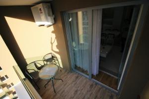 a small balcony with a chair and a window at Apartment Nova Otoka in Sarajevo