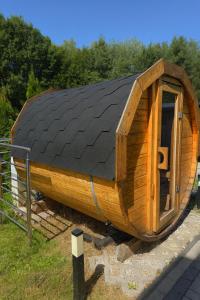 a small wooden house with a black roof at Leśny Zakątek I Małe Bieszczady w Rzeszowie I grill sauna Starowiejska 6 Rzeszów in Rzeszów
