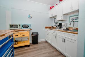 a kitchen with white cabinets and a sink at Park Place Unit 129 in Cedar Key +5 photos
