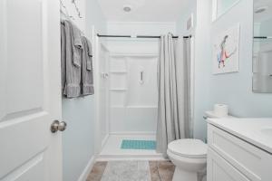 a white bathroom with a shower and a toilet at Park Place Unit 129 in Cedar Key