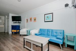 a living room with a blue couch and a table at Park Place Unit 129 in Cedar Key