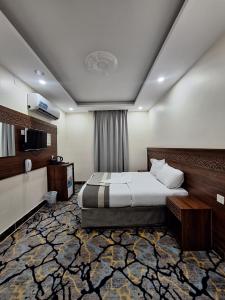 una habitación de hotel con una cama y un televisor en فندق برج الجميزة مكه, en La Meca