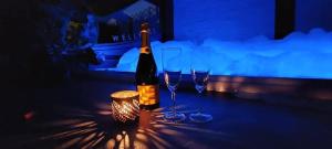 a bottle of wine sitting on a table with two wine glasses at Pause Thermale Suite in Herstal