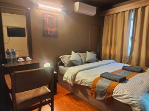 Un dormitorio con dos camas y una silla y un espejo. en Nepal Blissful Nest And Family Home, en Katmandú