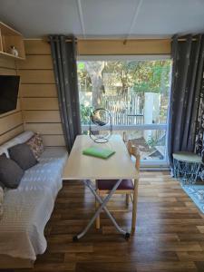 a room with a table and a couch in a room at Logement dans terrain privé et familiale in Bonifacio