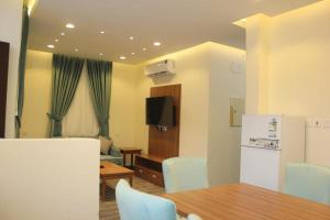 a kitchen and dining room with a table and a refrigerator at شاليه التميز الراقي - الهدا in Taif