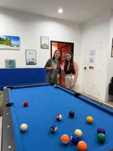 two women standing next to a pool table at Global Beach Hostel - Ao Nang in Ban Khlong Haeng