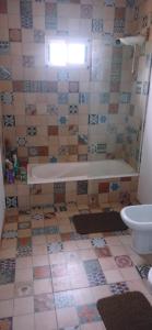 une salle de bain avec baignoire et sol carrelé dans l'établissement Las Golondrinas, à Veinticinco de Mayo