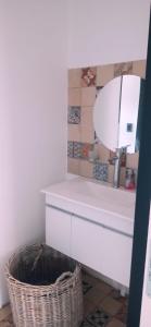 une salle de bain avec un lavabo, un miroir et un panier dans l'établissement Las Golondrinas, à Veinticinco de Mayo
