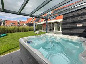 a hot tub in the backyard of a house at Coast and Calm 63 in Colijnsplaat