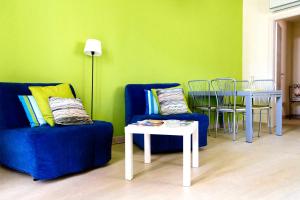 a living room with a blue couch and a table at Appartamento Verde Taormina in Taormina