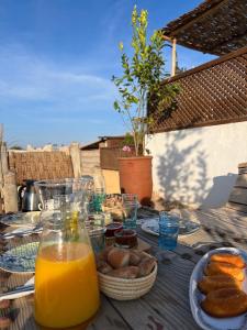 une table avec un tas de nourriture et des verres de jus d'orange dans l'établissement Riad Maiya, à Marrakech 19 autres photos