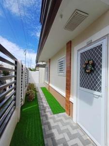 una puerta delantera de una casa con césped verde en MJs Residence, en General Santos