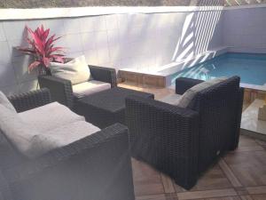 a swimming pool with wicker chairs and a table and a swimming pool at Océan Voyages Mitsamihouli in Mitsamiouli +18 photos