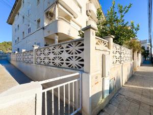 a white fence in front of a building at Tramuntana Beach in Calafell