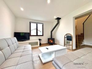 Una sala de estar con un sofá y un televisor. en Le Cocon de Marnaz - Convivial et Chaleureux, en Marnaz