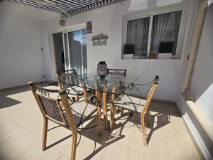 un tavolo da pranzo in vetro e sedie su un balcone di Las Dos Orillas a Costa Calma Altre 22 foto
