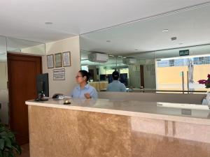 a woman standing at a counter in a hospital at Rig Vêda Hotel in Lima
