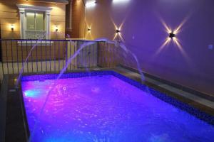 a swimming pool with purple lights in a room at شاليه التميز الراقي - الهدا in Taif +8 photos