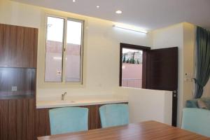 a kitchen with a sink and a table and chairs at شاليه التميز الراقي - الهدا in Taif
